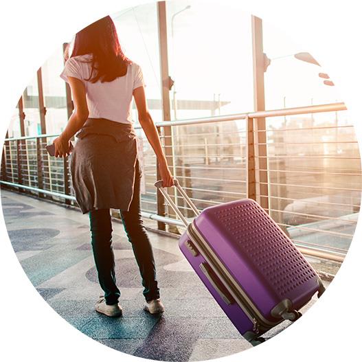 Woman with a rolling suitcase in an airport
