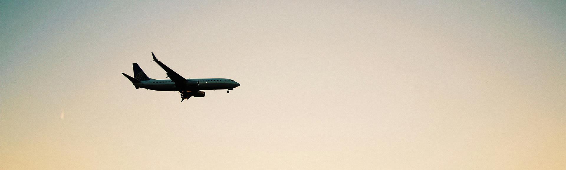 Plane flying high in the sky at dusk